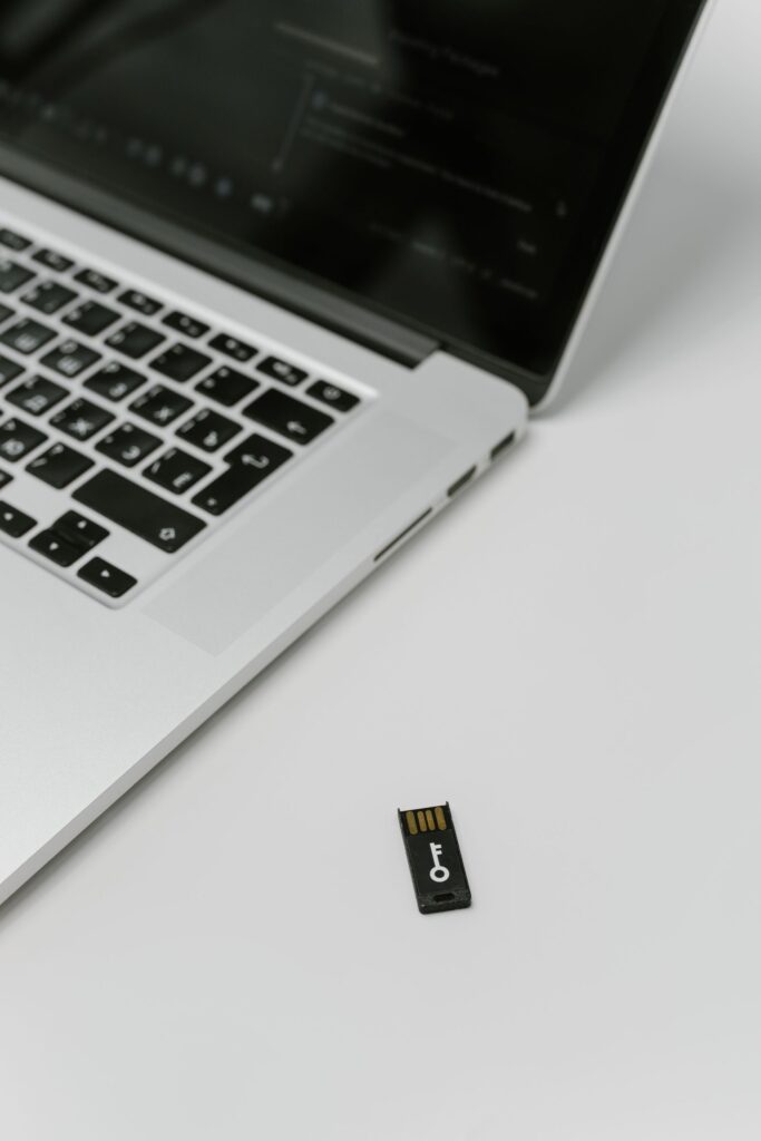 Laptop mit einem daneben liegenden Hardware-Sicherheitsschlüssel für die Zwei-Faktor-Anmeldung