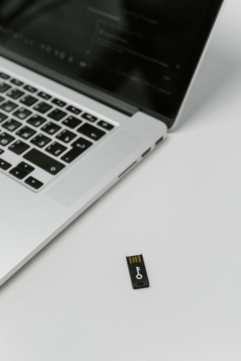 Laptop mit einem daneben liegenden Hardware-Sicherheitsschlüssel für die Zwei-Faktor-Anmeldung