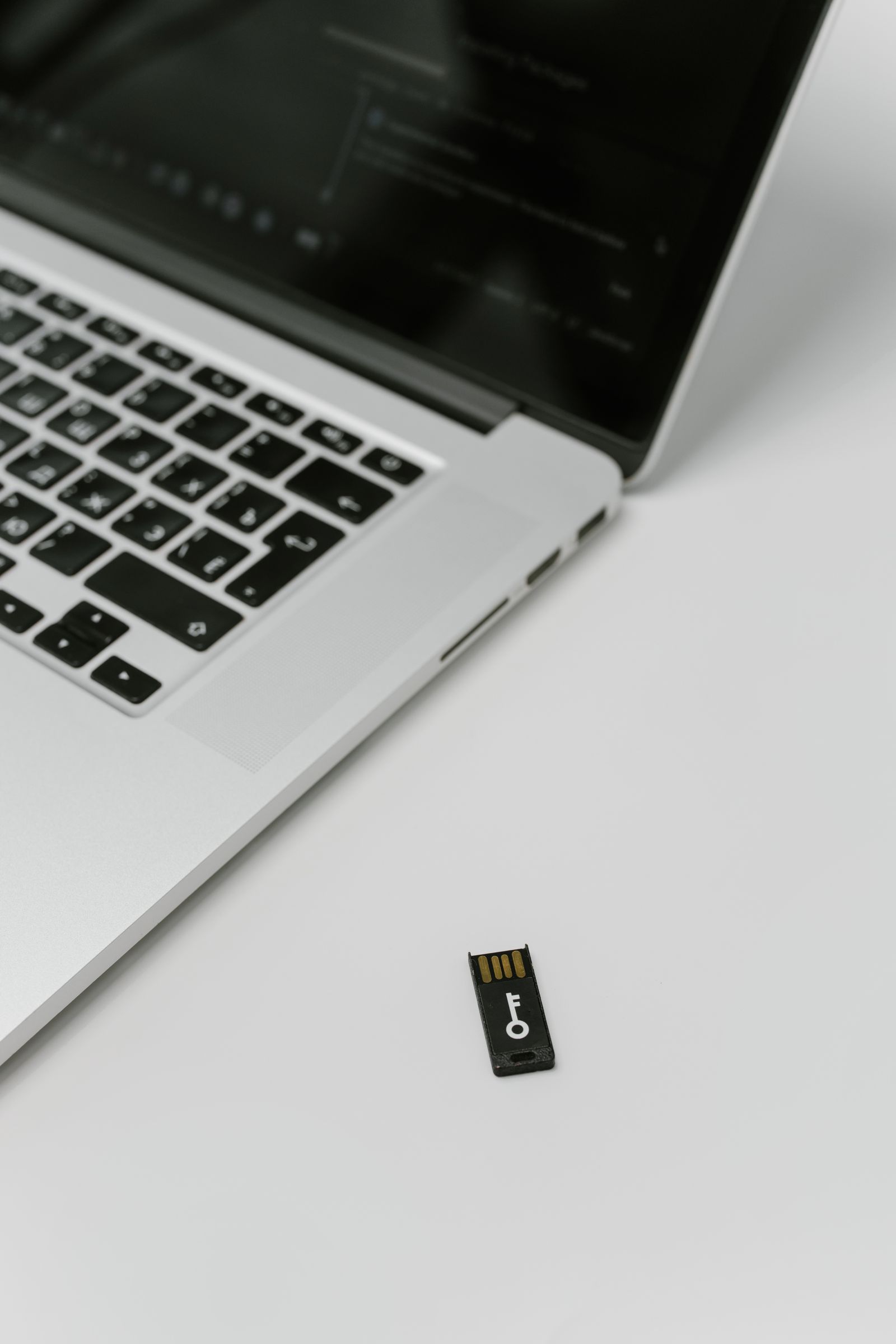 Laptop mit einem daneben liegenden Hardware-Sicherheitsschlüssel für die Zwei-Faktor-Anmeldung